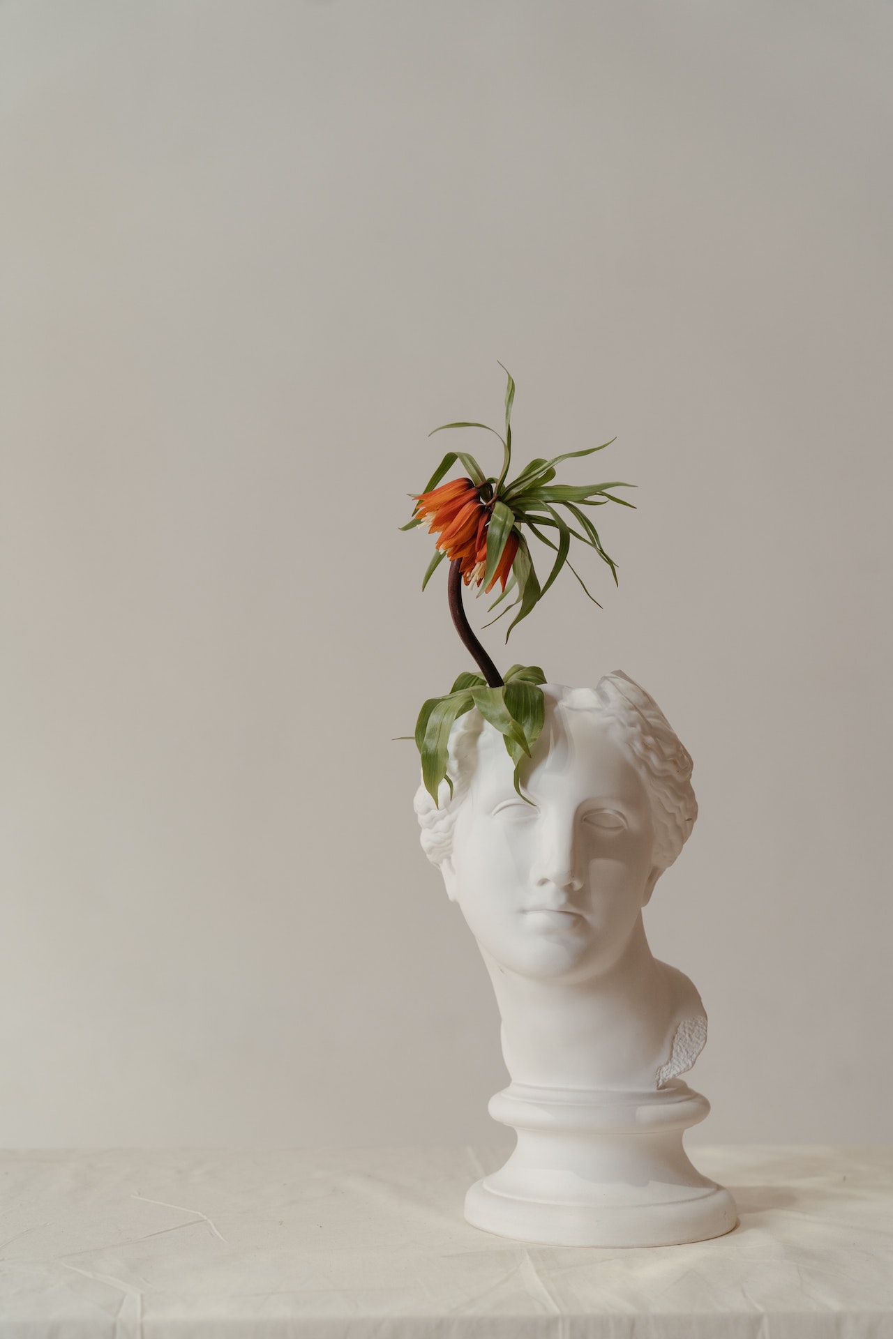 sculpture with a flower on its head
